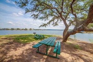 A lakeside picnic area with a bench and a picnic table. - Community Boat Ramp! Family Escape w/ Fenced Yard (Granbury)