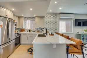 A modern kitchen with a central island, stainless steel appliances, and a patterned backsplash. - Walk to Beach & Dtwn! Extended San Clemente Escape (San Clemente)