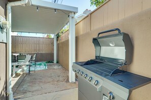 An outdoor patio with a NEXGRILL barbecue grill, a covered seating area, and a wooden fence. - Walk to Beach & Dtwn! Extended San Clemente Escape (San Clemente)