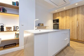 Eine moderne Küche mit Kochinsel, Backofen und Holzschränken.