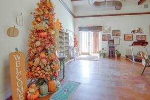 A spacious living area with a decorative autumn-themed centerpiece, a reception desk, and a view of the outdoors. - 100-Acre Working Ranch, Fishing Lake! Texas Escape (Denton)