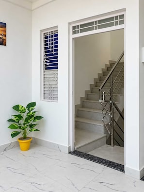 Una escalera con barandilla de metal y una planta en maceta a un lado.