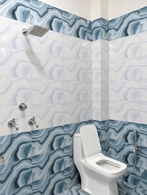 Et badeværelse med et moderne design, der inkluderer toilet, brusebad og vask.