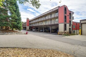 A multi-story parking garage with a red and beige color scheme, outdoor parking spaces, and a fire hydrant. - Breckenridge Ski Condo: Easy Bus to Slopes (Breckenridge)