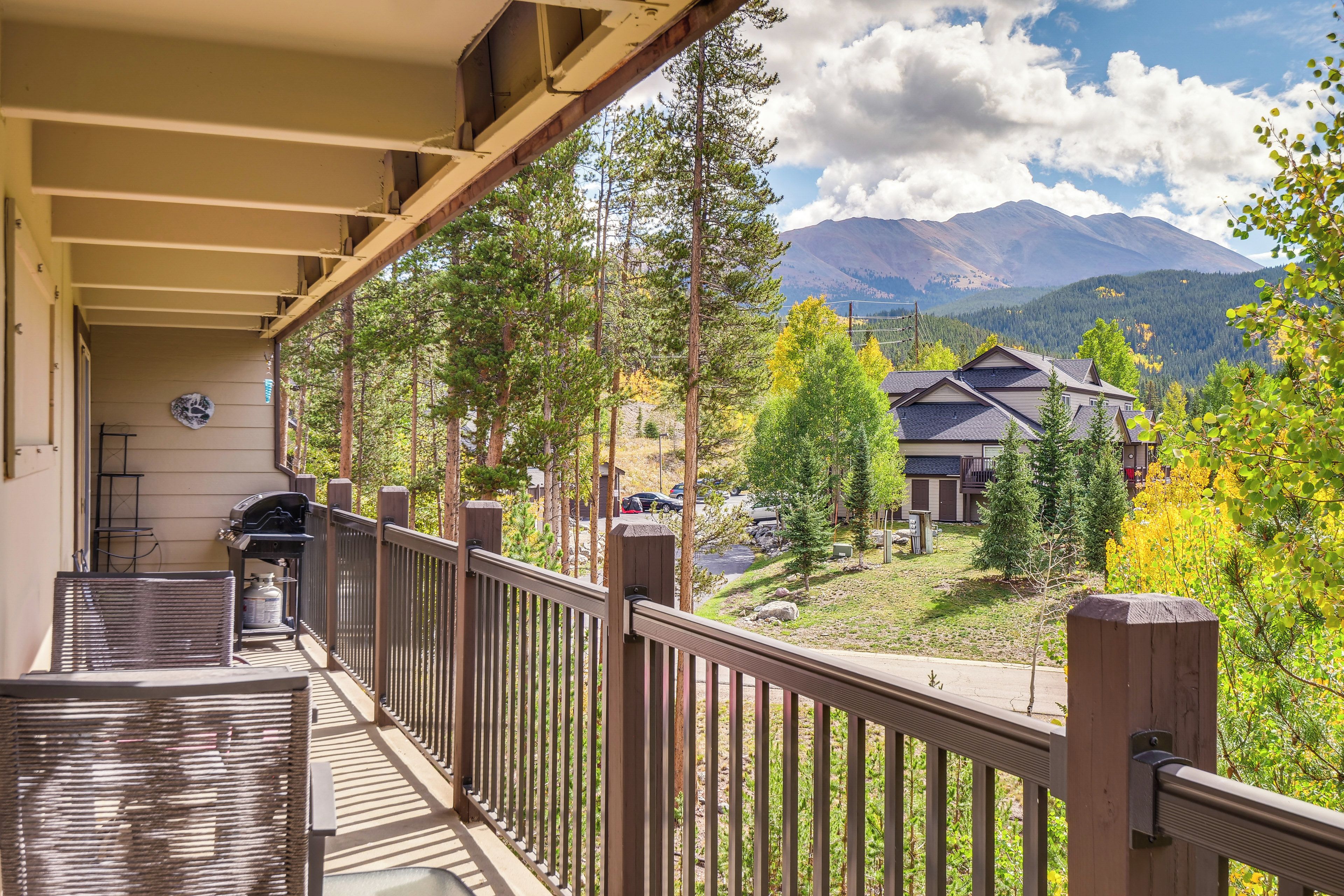 A balcony with a view of a mountain range and a residential area.