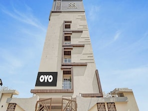 A tall hotel building with a prominent 'SS GRAND' sign at the top and a 'OYO' sign on the lower facade. - Collection O Halcyon SS Grand (Hyderabad)