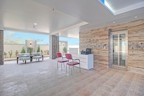 A modern reception area with a marble wall, a reception desk, and seating. - Collection O Halcyon SS Grand (Hyderabad)