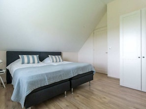 A bedroom with a bed, a nightstand, and a wardrobe. - "t Hof van Schouwen (Burgh-Haamstede)