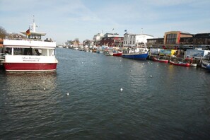 A harbor with boats docked, a building with a flag, and a clear sky. - Bungalow with 2 bedrooms (Ostseebad Nienhagen)