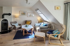 A cozy living room with a fireplace, a dining table, and comfortable seating. - Aft deck W. 8 || Prerow (Prerow)