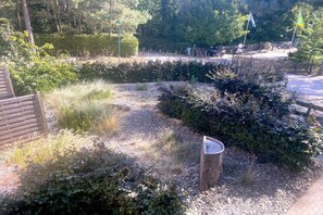 A landscaped garden with a wooden bench, gravel paths, and dense shrubbery. - Holiday apartment with 1 bedroom (Koserow)