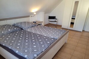 A bedroom with a bed, a nightstand, a chair, and a wardrobe. - Holiday home with 1 bedroom (Zinnowitz)