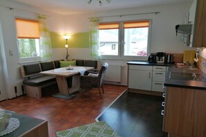A compact kitchen with a dining area, a built-in oven, and a coffee maker. - Holiday apartment with 2 bedrooms (Ramsau im Zillertal)