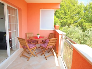 A balcony with a table and chairs, a potted plant, and a view of greenery. - Apartments Villa Rea Orebic - One Bedroom Apartment With Terrace (Orebic)