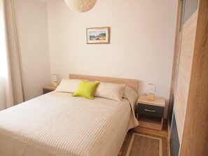A bedroom with a bed, bedside tables, a lamp, a nightstand, a picture on the wall, and a window with curtains. - Apartments Villa Rea Orebic - One Bedroom Apartment With Terrace (Orebic)