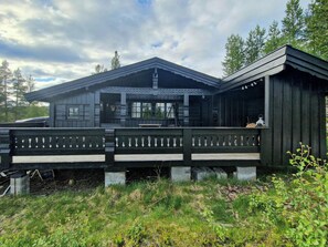 A wooden cabin with a porch and a covered area, surrounded by greenery. - Traditional cabin with views over Setesdalen (Bykle)