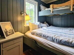 A bedroom with a bunk bed, a bedside table with a lamp, and a framed picture on the wall. - Traditional cabin with views over Setesdalen (Bykle)