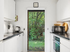A compact kitchen with white cabinetry, a coffee maker, a microwave, and a toaster. - "Tordis" - 675m from the sea by Interhome (Gilleleje)
