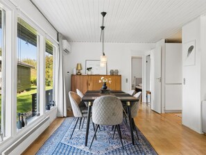 A dining area with a wooden table, chairs, and a patterned rug. - "Tordis" - 675m from the sea by Interhome (Gilleleje)