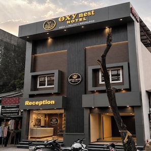 A hotel named OXYnest with a reception area and a sign indicating services like rest, relax, and recharge. - Oxynest Hotel (Haldwani)