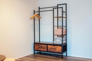 Ein hoher, schmaler Schrank mit mehreren Regalen und Schubladen, vermutlich zur Aufbewahrung von Bettwäsche oder Kleidung.