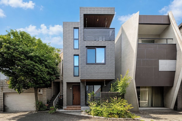 Un moderno edificio residencial de varios pisos con techo plano, ventanas amplias y un diseño minimalista.