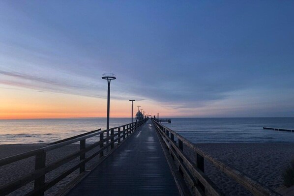 A wooden pier extending into the sea with a clear sky above. - Holiday apartment "Am Ostseedeich" (Zingst)