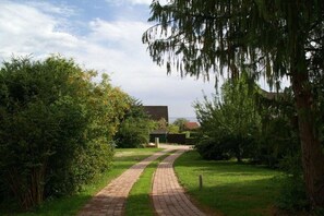 Un chemin menant à un bâtiment entouré de verdure.
