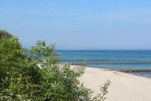 Ein Strand mit klarem, blauem Wasser und einem Sandufer.