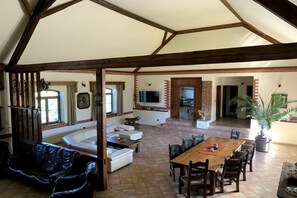 A spacious living area with a wooden dining table, sofas, and a TV. - ||---------------------Valahof Barn----------------------|| (Milevsko)