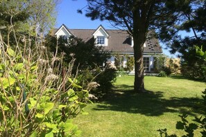 A house with a sloped roof, a front porch, and a well-maintained lawn. - Holiday apartment in Nieby with swimming pool (Nieby)