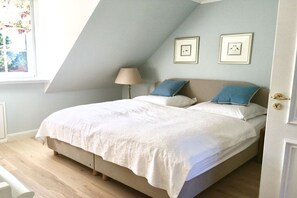 A bedroom with a bed, a lamp, and two framed pictures on the wall. - Holiday apartment in Nieby with swimming pool (Nieby)