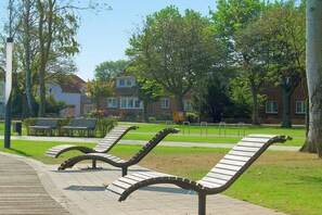 A park with benches and a paved walkway. - Holiday home with 1 bedroom (Heiligenhafen)