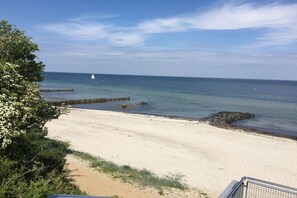 A beach with clear skies, a sandy shore, and a distant sailboat. - Holiday apartment with 1 bedroom (Hohwacht)