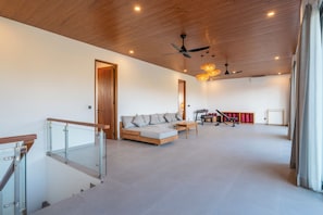 A spacious living area with a wooden ceiling, a sofa, a coffee table, and a ceiling fan. - Frankie's Villas (Klungkung)