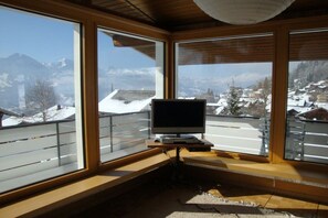 A room with large windows offering a view of snow-covered mountains. - Holiday apartment with 2 bedrooms (Beatenberg)