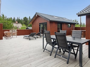 A deck with a table and chairs, a covered area, and a building with a tiled roof. - "Ellin" - 3.3km from the sea by Interhome (Rømø)