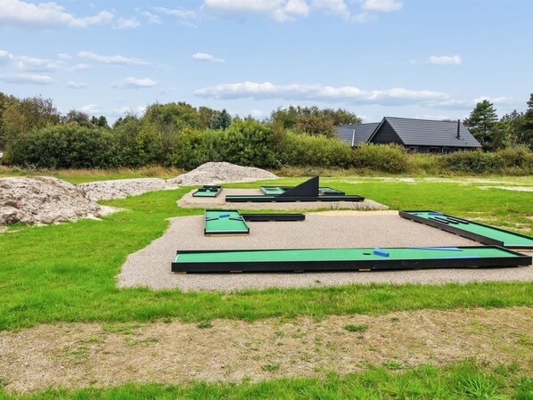 A series of mini-golf courses with green playing surfaces and black borders, surrounded by gravel and grass. - "Ellin" - 3.3km from the sea by Interhome (Rømø)
