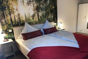 Une chambre à coucher avec un lit, des tables de chevet, une lampe et une armoire.