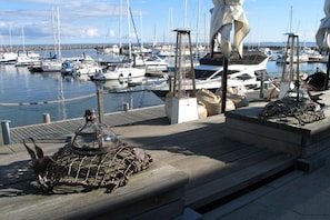 A marina with boats docked, a wooden deck, and a statue. - Holiday apartment with 1 bedroom (Kühlungsborn)