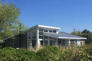A modern two-story building with large windows and a sloped roof. - Holiday home in Ballum with swimming pool (Ballum)