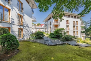 A residential building with multiple balconies, a well-maintained lawn, and a clear sky. - Vrbo Property (Heringsdorf (Seebad))