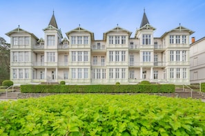 A large, multi-story building with a symmetrical facade, multiple balconies, and a central tower. - Vrbo Property (Zinnowitz)