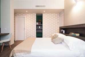A bedroom with a bed, bedside table, and a desk with a chair. - Contempora - Cavallotti 13 - Two-room apartment with a terrace on the top floor - A64 (Milano)