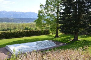 A greenhouse structure in a grassy area with a mountain backdrop. - Holiday apartment with 2 bedrooms (Baldramsdorf Kärnten)