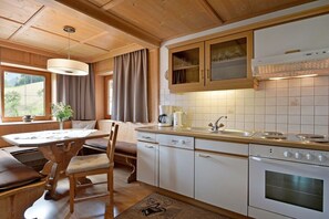 A kitchen with wooden cabinets, a stove, and a sink. - Holiday apartment in Hippach with Wi-Fi (Hippach)