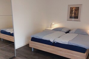 Ein Schlafzimmer mit Bett, Nachttisch, Lampe und einem gerahmten Bild an der Wand.