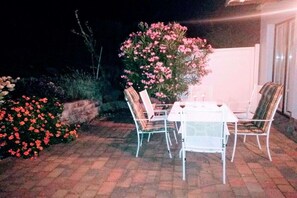 An outdoor patio with a table and chairs, surrounded by flowering plants. - Luxury holiday home by the sea (Mönchgut Ortsteil Gager)