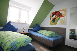 A bedroom with a bed, a bedside table, a lamp, a window, and a painting on the wall. - Holiday home with 4 bedrooms (Zinnowitz)