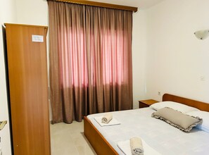 A hotel room with a bed, a nightstand, a wooden wardrobe, and a window with curtains. - Apartments Adriana Studio Apartment 6 (Gradac)